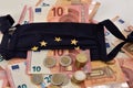 Close-up of euro bills and diy facemask, designed as an European Union flag. Royalty Free Stock Photo