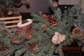 Close up of an evergreen garland with pinecones, a small child`s hiking boot and mitten
