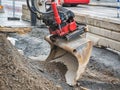 Close up of excavator, grader or tractor bucket, city road renovation at the background Royalty Free Stock Photo