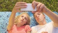 CLOSE UP: Excited young woman and man making funny faces and taking selfies. Royalty Free Stock Photo