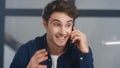 Portrait of positive guy supporting client on phone. Man making winner gesture Royalty Free Stock Photo