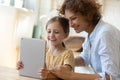 Close up mother and little daughter having fun with tablet