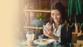 Close up excited young Asian businesswoman is watching a trading graph by her cell phone while while lunch time at canteen Royalty Free Stock Photo