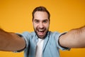 Close up of excited young man in casual blue shirt posing isolated on yellow orange wall background, studio portrait Royalty Free Stock Photo