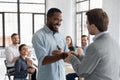 Close up executive shaking successful African American employee hand