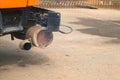 Close-up exhaust pipe of working construction machine on construction site.