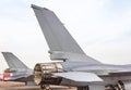 Close up exhaust and tail fin side of fighting military fighter jet aircraft parked on runway