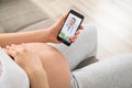 Close-up Of Expecting Woman Videoconferencing With Doctor