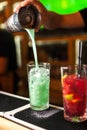 Close-up of expert bartender making blue, turquoise and red cocktails in bar Royalty Free Stock Photo