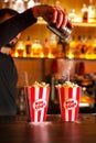 Close-up of expert bartender making popcorn cocktail in bar. Bartender finishes preparation of orange alcoholic popcorn cocktail b Royalty Free Stock Photo