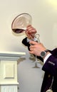Close-up of expert sommelier or oenologist man dressed in formal black clothes pouring red wine