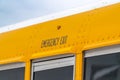 Close up of the exterior of a yellow school bus with an Emergency Exit sign Royalty Free Stock Photo