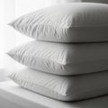 Stack of Three White Down Pillows Resting on a White Surface with Soft Natural Light comfort Royalty Free Stock Photo