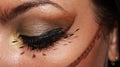 Close up of an eye tribal inspiration professional make up in gold, brown and black color with fantasy false lashes Royalty Free Stock Photo