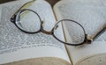 Close up of eyeglasses on top of an open book Royalty Free Stock Photo