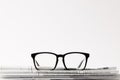 close up of eyewear on pile of newspapers, on white background with copy space