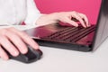 Close up f an elderly woman hands on mouse and laptop keyboard. She plays computer games or searching in web, chatting in social Royalty Free Stock Photo