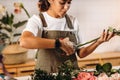 Close up f young woman florist cutting flowers