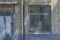 Close-up of the facade of an old brick building with a barred window and a metal door Royalty Free Stock Photo