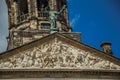 Close-up of facade with sculptures and dome with golden clock in the Royal Palace of Amsterdam.