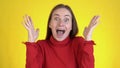 Close-up face of amazed woman shocked. Handsome girl surprised to camera over yellow background. Royalty Free Stock Photo