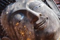 Close up face of ancient old face Buddha statue with gold leaf foil at Thailand temple Royalty Free Stock Photo