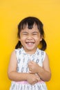 close up face of asian kid toothy smiling facial face with happiness emotion on yellow wall use for children lovely emotion and d Royalty Free Stock Photo