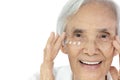 Close-up,Face of asian senior woman applying eye cream,anti-aging,nourishing under eye,facial treatment,happy smiling old elderly Royalty Free Stock Photo