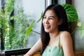 Close-up of the face of a beautiful Asian woman with long hair Smiling happily, a young woman sits and chats with her friends in a