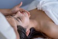 Close up face of beautiful Asian woman is treat with massage in spa room to get good health Royalty Free Stock Photo