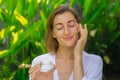 Close up of the face of a beautiful middle-aged woman. A woman applies cream. Royalty Free Stock Photo