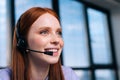 Close-up face of beautiful young woman operator using headset during customer support at home office. Royalty Free Stock Photo