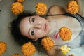 close-up of the face and bust of the girl lying in the water with floating around buds of yellow flowers Royalty Free Stock Photo