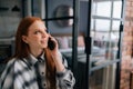 Close-up face of cheerful young woman holding mobile phone happily calling and chatting at home, smiling looking away. Royalty Free Stock Photo