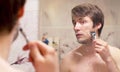 Shaving man reflected in the mirror Royalty Free Stock Photo