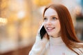 Close-up face of happy attractive redhead young woman talking on mobile phone standing in shopping mall with bright Royalty Free Stock Photo