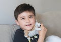 Close up face happy kid with smiling face, Cute young boy sitting on sofa playing with dog toy relaxing at home on weekend,Indoor Royalty Free Stock Photo