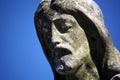 Close up face of Jesus Christ crumbling moss covered stone graveyard statue. Royalty Free Stock Photo