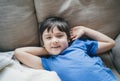 Close up face of kid looking at camera with smiling, A happy boy lying on sofa relaxing on weekend, Comfortable Child laying down Royalty Free Stock Photo