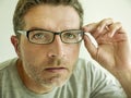 Close up face portrait of attractive man checking vision trying glasses at optometrist . guy 40s during optical examination