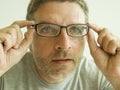 Close up face portrait of attractive man checking vision trying glasses at optometrist . guy 40s during optical examination