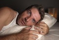 Close up face portrait of sleepless and awake attractive man with eyes wide open at night lying on bed suffering insomnia sleeping Royalty Free Stock Photo