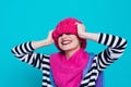 Close up face portrait of toothy smiling young woman wearing knitted pink hat and scarf. Royalty Free Stock Photo