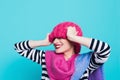 Close up face portrait of toothy smiling young woman wearing knitted pink hat and scarf. Royalty Free Stock Photo