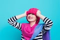 Close up face portrait of toothy smiling young woman wearing knitted pink hat and scarf. Royalty Free Stock Photo