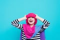 Close up face portrait of toothy smiling young woman wearing knitted pink hat and scarf. Royalty Free Stock Photo