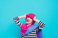 Close up face portrait of toothy smiling young woman wearing knitted pink hat and scarf. Royalty Free Stock Photo