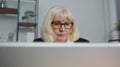 Senior business woman freelancer using laptop computer sits at workplace typing browsing at office Royalty Free Stock Photo