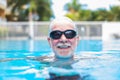 Close up of face of senior or mature man swimming and having fun at the pool - training and enjoy alone Royalty Free Stock Photo