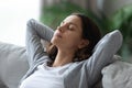 Closeup serene woman face closed eyes leaned on couch indoors Royalty Free Stock Photo